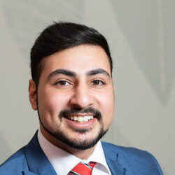 Portrait of Mishan in red tie and blue suit